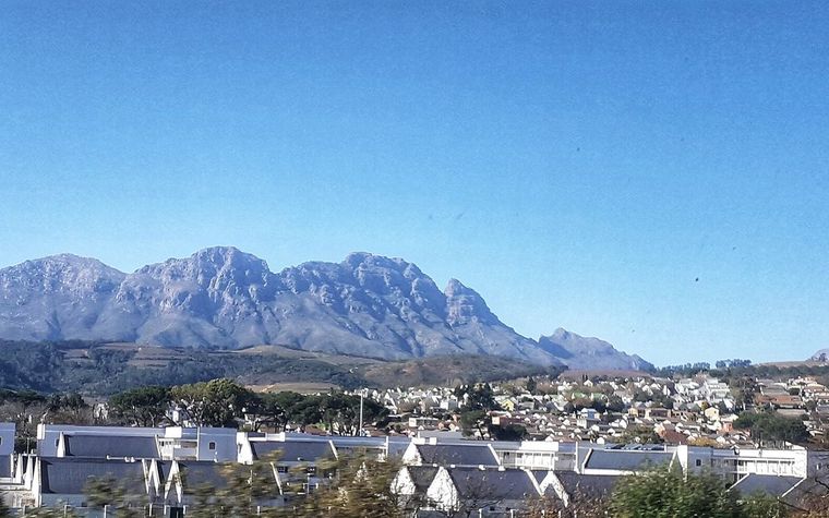 Historic Cape Dutch architecture and oak-lined streets in Stellenbosch, vineyards and mountains beyond